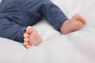 Yeni doğmuş bebek beyaz battaniyeye uzanıyor, yakın plan.