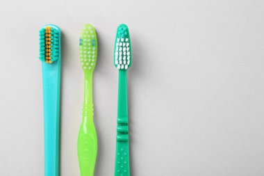 Arka planda birçok farklı diş fırçası, düz bir zemin. Metin için boşluk