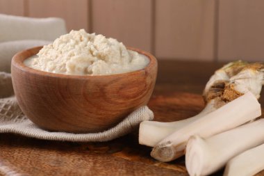 Baharatlı yaban turpu sosu kasede ve kökler masada, yakın plan.