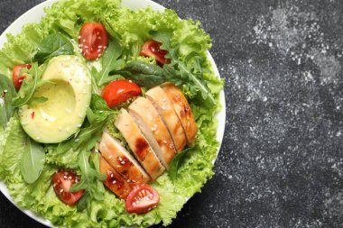 Tavuk, vişneli domates ve gri desenli masada avokado ile nefis bir salata. Metin için boşluk