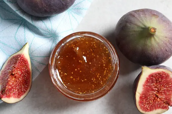 Lezzetli tatlı reçel kavanozu ve taze incir Işık masasında, düz yatıyordu