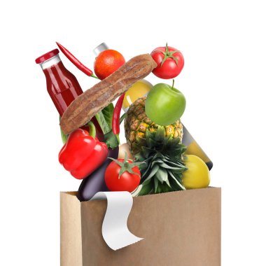 Farklı gıda ürünleri beyaz arka planda kese kağıdına düşüyor.