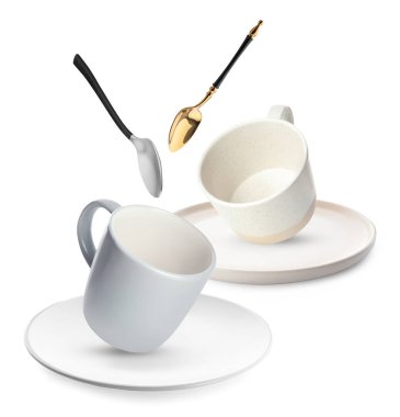 Temiz tabaklar, kaşıklar ve fincanlar beyaz arka plana düşüyor