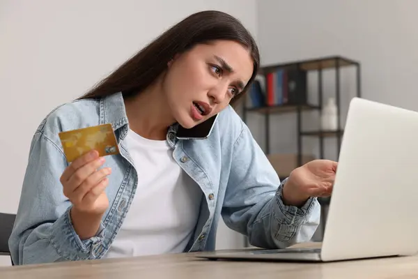 Zdezorientowana Kobieta Kartą Kredytową Rozmawiająca Przez Telefon Używająca Laptopa Przy — Zdjęcie stockowe