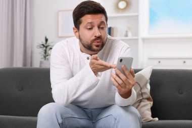 Evdeki akıllı telefondan görüntülü konuşma sırasında öpüşen bir adam. Uzun mesafeli ilişki