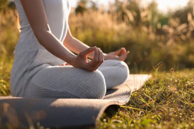 Dışarıdaki yoga minderinde Padmasana antrenmanı yapan bir kadın, mesaj için yeri olan yakın plan. Lotus pozu