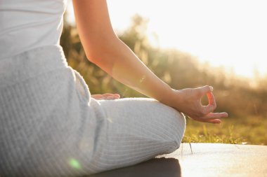 Dışarıdaki yoga minderinde Padmasana egzersizi yapan kadın, yakın plan. Lotus pozu