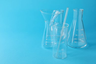 Açık mavi arka planda farklı bir laboratuvar camı var. Metin için boşluk