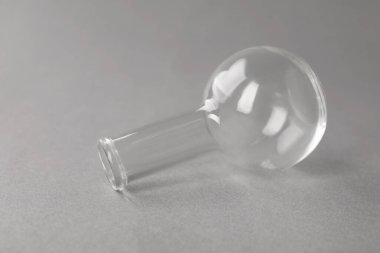 Gri arka planda bir şişe, yakın plan. Laboratuvar camları.