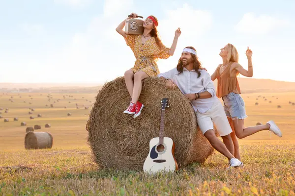 Radyo alıcısı ve gitarı olan mutlu hippi arkadaşlar sahada, mesaj için yer var.