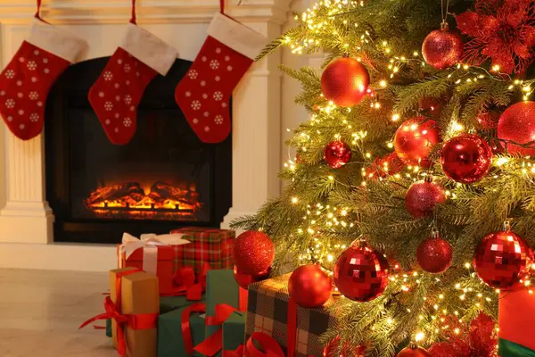 屋内で飾られたクリスマスツリーと暖炉の下の多くのギフトボックス — ストック写真