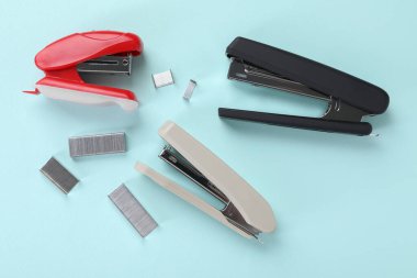 Açık mavi arka planda zımba zımbaları, düz yatış