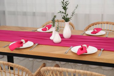 Yemek odasında yeşil dalları olan güzel masa düzenleri ve vazolar.