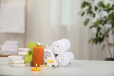 Beyaz mermer masa içerisindeki farklı spa ürünleri ve plumeria çiçekleriyle kompozisyon, metin için boşluk