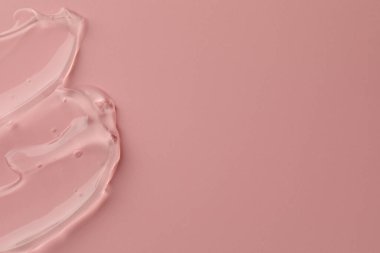 Pembe arka planda temiz kozmetik jel örneği, üst manzara. Metin için boşluk