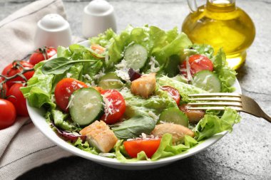 Gri masada tavuklu, peynirli ve sebzeli lezzetli salata yemek.