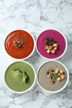 Beyaz mermer masada farklı lezzetli krema çorbaları, düz yatış.