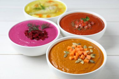 Lezzetli çorba ve beyaz ahşap masada farklı krema çorbaları, yakın plan.