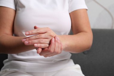 Bulanık arka planda kozmetik krem süren kadın, yakın plan.