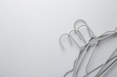 Açık gri arka planda askılar, üst manzara. Metin için boşluk