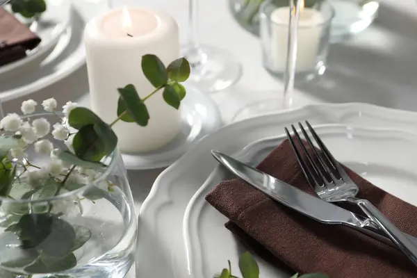 Beautiful table setting with silverware and floral decor, closeup