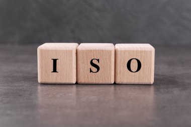 Gri dokulu masa üzerinde ISO kısaltması olan tahta küpler.