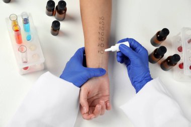 Doktor ışık masasında cilt alerjisi testi yapıyor.