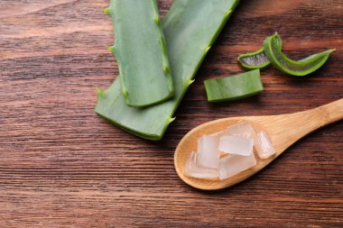 Aloe vera jeli ve ağaç dilimleri ahşap masada, düz yerde. Metin için boşluk