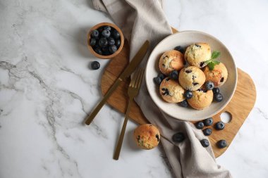 Kasede yaban mersini ve beyaz mermer masada çatal bıçaklı lezzetli çörekler, düz konum. Metin için boşluk