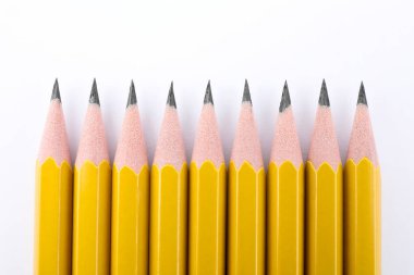 Beyaz arkaplanda birçok keskin grafit kalem, üst görünüm