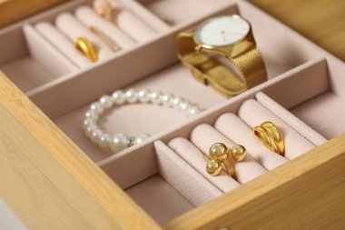 Ahşap çekmecede bir sürü farklı aksesuar bulunan mücevher kutusu, yakın plan.