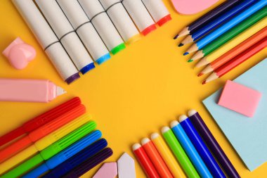 Sarı arka planda farklı okul kırtasiyesi çerçevesi, mesaj için yeri olan düz bir tabaka. Okula geri dön.