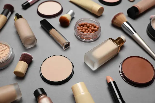 Face powders and other makeup products on grey background