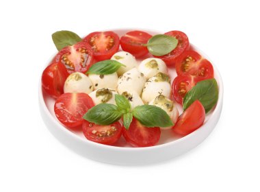 Bir tabak lezzetli Caprese salatası, mozzarella, domates, fesleğen ve pesto sosu beyaz üzerine izole edilmiş.