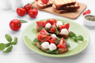 Mozzarella, domates, fesleğen ve pesto soslu lezzetli Caprese sandviçleri.