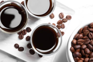 Beyaz masada bir bardak kahve likörü ve fasulye.