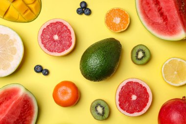 Sarı arka planda farklı olgun meyveler, düz uzanmış