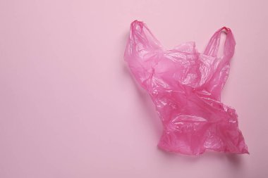 Pembe arka planda bir plastik torba, üst manzara. Metin için boşluk