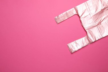Pembe arka planda bir paket plastik torba, üst manzara. Metin için boşluk