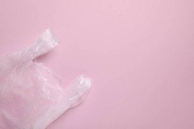 Pembe arka planda bir plastik torba, üst manzara. Metin için boşluk