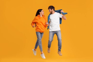 Mutlu çift turuncu arka planda dans ediyor.