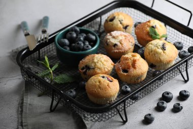 Yaban mersinli lezzetli kekler ve açık gri masada nane şekeri. Yakın plan.