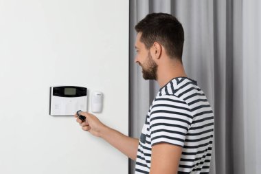 Ev güvenlik sistemi. Alarm anahtarı kullanan adam içeride.