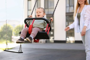 Dadı ve şirin çocuk dışarıda salıncakta sallanıyor.