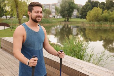 İskandinav usulü yürüme pratiği yapan bir adam. Metin için boşluk