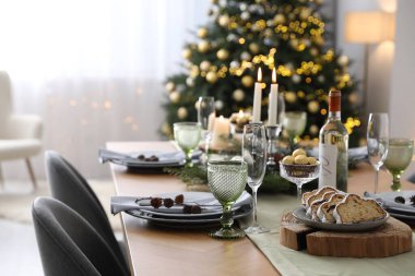 Noel sofrası dekorasyonu ve bulaşık takımlarıyla dolu.