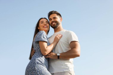 Romantik bir randevu. Güzel bir çift mavi gökyüzüne karşı birlikte zaman geçiriyor, alçak açılı bir manzara.