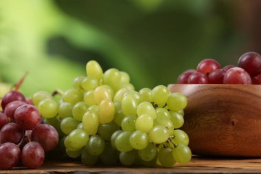 Tahta masadaki farklı olgun üzümler bulanık arka planda, yakın planda