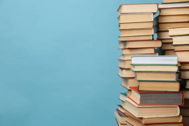 Turkuaz arka plan üzerine bir sürü ciltli kitap, metin için boşluk. Kütüphane materyali