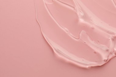 Pembe arka planda temiz kozmetik jel örneği, üst manzara. Metin için boşluk